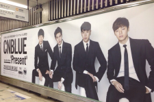 CNBLUEの特大ポスター登場！　JR渋谷駅ホームにベストアルバム『Present』のジャケット写真。